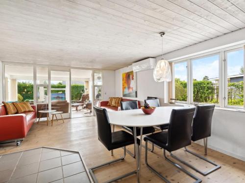 a living room with a table and chairs and a couch at Holiday Home Mena - 200m from the sea by Interhome in Børkop