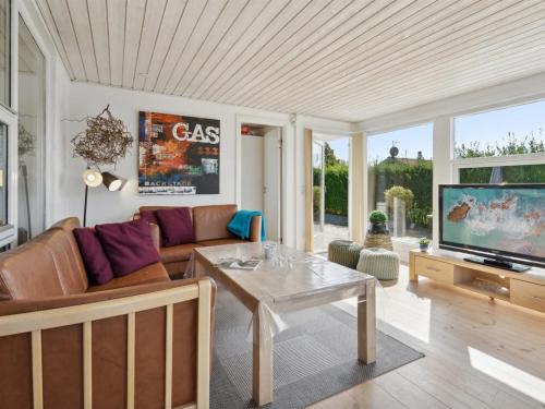 a living room with a couch and a table at Holiday Home Mena - 200m from the sea by Interhome in Børkop