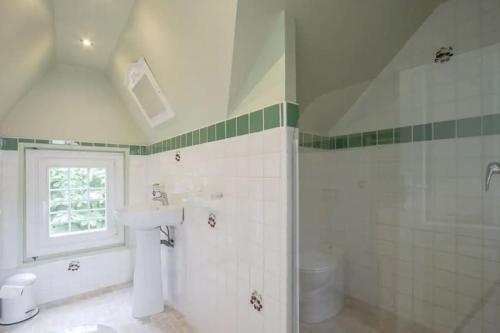 une salle de bain blanche avec un lavabo et une douche dans l'établissement Maison ensoleillée centre de deauville, à Deauville