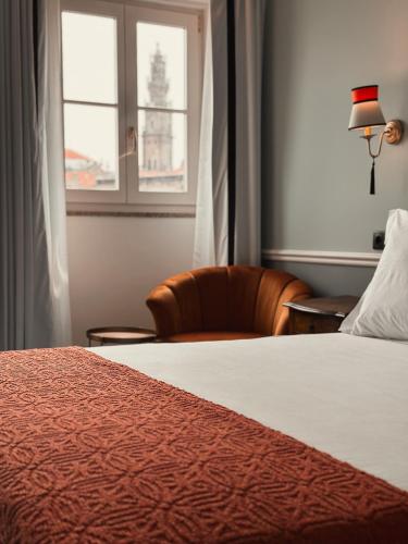 a bedroom with a bed and a chair and a window at GRANDE HOTEL PARIS by STAY HOTELS in Porto
