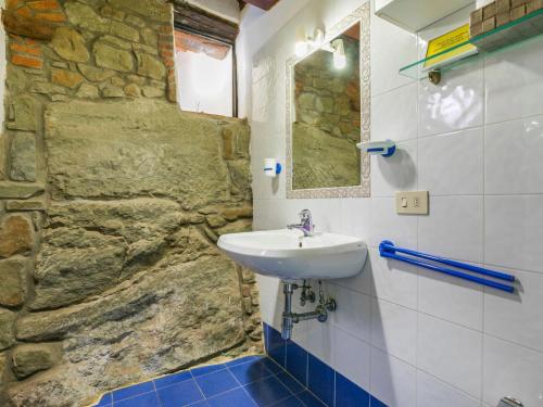 a bathroom with a sink and a stone wall at Holiday Home Ridaldi by Interhome in Greve in Chianti