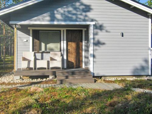 une maison avec une terrasse couverte dotée de 2 chaises et d'une porte dans l'établissement Holiday Home Riekko by Interhome, à Enontekiö