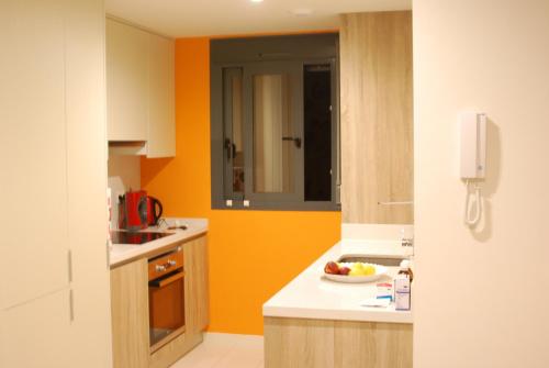Los AltosにあるEgeo 3011の- オレンジ色の壁のキッチン、カウンターにフルーツを用意しています。