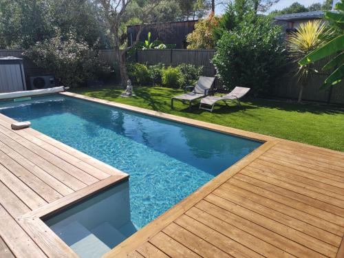 - une piscine dans un jardin avec une terrasse en bois dans l'établissement Holiday Home La Bruyère by Interhome, à Saubion