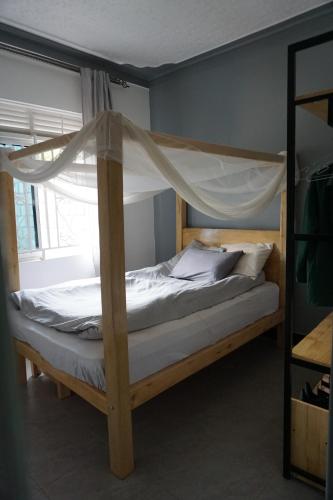 Schlafzimmer mit einem Bett mit Moskitonetz in der Unterkunft Welcome to the orchid. in Sisa