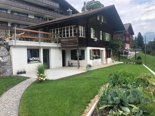 une grande maison avec une pelouse devant elle dans l'établissement Apartment Lohnerblick by Interhome, à Adelboden
