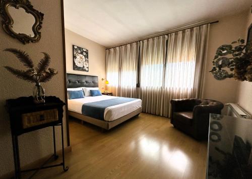 1 dormitorio con 1 cama, 1 silla y 1 ventana en Hostal Rural Moratín, en Pastrana