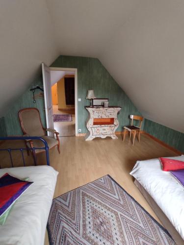 a attic room with two beds and a piano at Privatisation d'un étage - 2 chambres & 1 salle d'eau - 4 pers in La Chapelle-Saint-Aubin