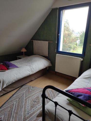 een slaapkamer op zolder met 2 bedden en een raam bij Privatisation d'un étage - 2 chambres & 1 salle d'eau - 4 pers in La Chapelle-Saint-Aubin