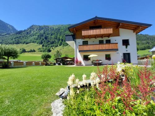 a house in the mountains with a green yard at Apartment Apartement Haus Dankl by Interhome in Fusch an der Glocknerstraße