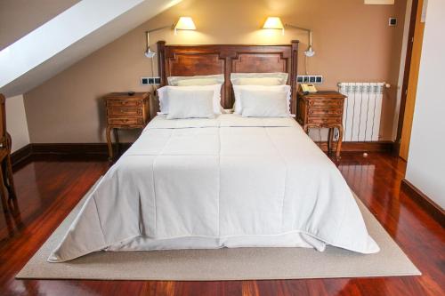 1 dormitorio con 1 cama grande y edredón blanco en Hotel Mirador de Moriyón, en Miravalles