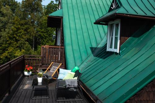 a deck with a green roof and a green house at Willa JODŁA Wisła in Wisła