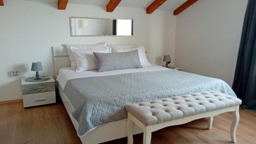 a white bedroom with a large bed with a tufted mattress at Apartman Diana,free parking in Pula