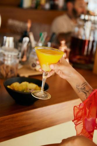 a person holding up a glass with an orange drink at Zel Mallorca in Palmanova