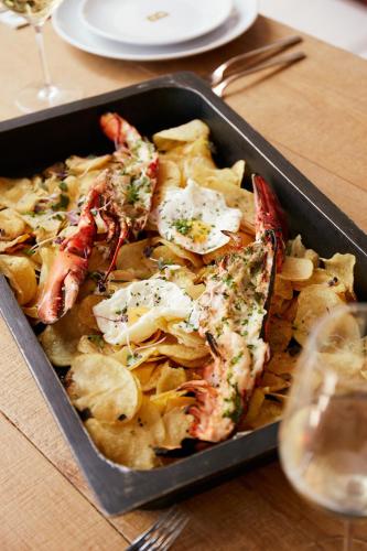 a tray of food with seafood and chips and a glass of wine at Zel Mallorca in Palmanova