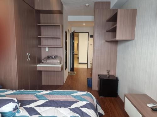 1 dormitorio con cama, lavabo y pasillo en skyview apartemen by gowsleep en Sunggal