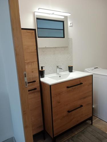 une salle de bain avec un lavabo et une fenêtre dans l'établissement Maison Dominique, à Balzac