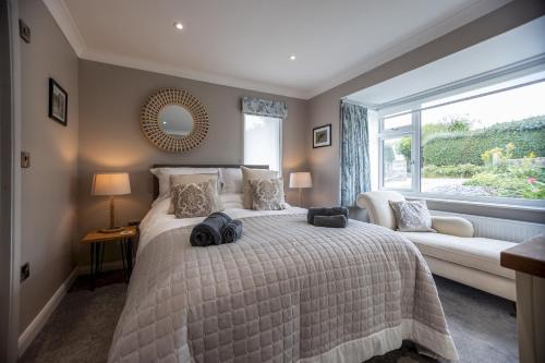 ein Schlafzimmer mit einem großen Bett und einem Fenster in der Unterkunft Stylish 2 bed pet-friendly coastal retreat in Braunton