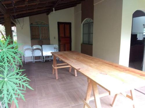 una mesa de madera en una habitación con sillas en Recanto São Romão, en Nova Friburgo