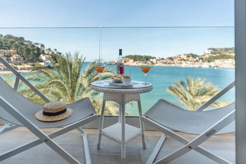 a table and chairs with wine glasses and a view of the ocean at Hotel Marina in Port de Soller