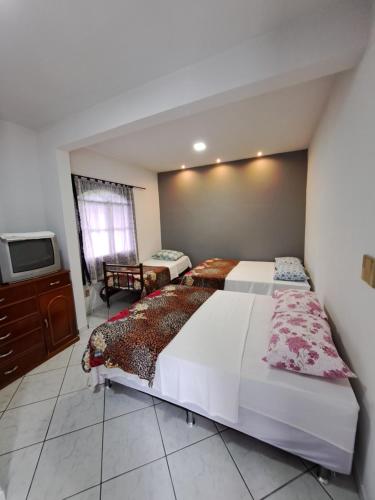 um quarto com 2 camas e uma televisão de ecrã plano em Recanto São Romão em Nova Friburgo