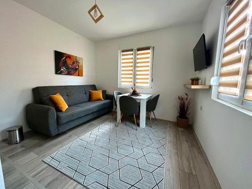 ein Wohnzimmer mit einem Sofa und einem Tisch in der Unterkunft Apartman "Lola" in Pirot