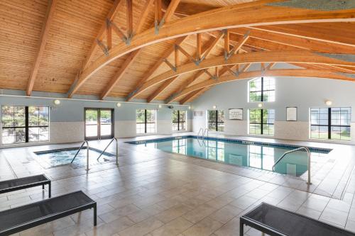 an indoor pool with a wooden ceiling and a swimming pool at Candlewood Suites Eagan - Mall of America Area by IHG in Eagan