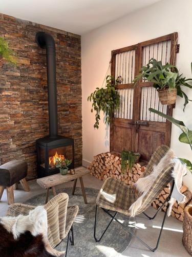 a living room with a wood stove and chairs at Hoeve BuytenHout in Delft