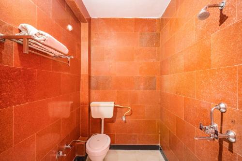 a tiled bathroom with a toilet and a shower at Hotel Classic Jaisalmer in Jaisalmer