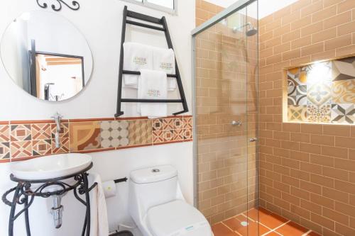 a bathroom with a toilet and a sink and a shower at Hotel Experiencia Viva in Mesa del Norte