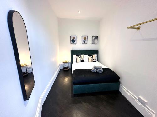 a small bedroom with a bed and a mirror at Modern 1-Bedroom Apartments in Shoreditch, Old Street in London