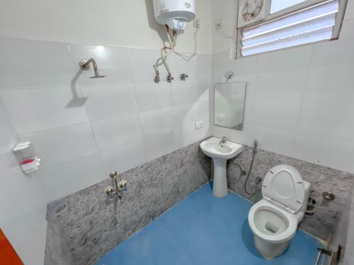 a bathroom with a toilet and a sink with a blue floor at Hotel Elite By Agira Hotels-Free Airport Pickup or Drop in Yelahanka