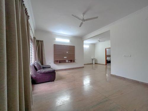a living room with a couch and a ceiling fan at Hotel Elite By Agira Hotels-Free Airport Pickup or Drop in Yelahanka