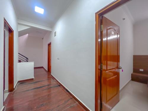 a hallway with a wooden door and a staircase at Hotel Elite By Agira Hotels-Free Airport Pickup or Drop in Yelahanka