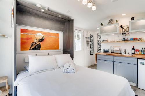 1 Schlafzimmer mit einem weißen Bett und einer Küche in der Unterkunft TINY ART HOUSE near the beat in Sacramento