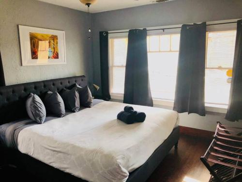 1 dormitorio con 1 cama grande y cortinas azules en Smart Spacious Artsy home near Midtown en Sacramento