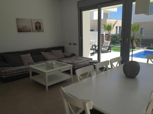 a living room with a couch and a table and chairs at 3018 Vistabella- Malibu in Orihuela