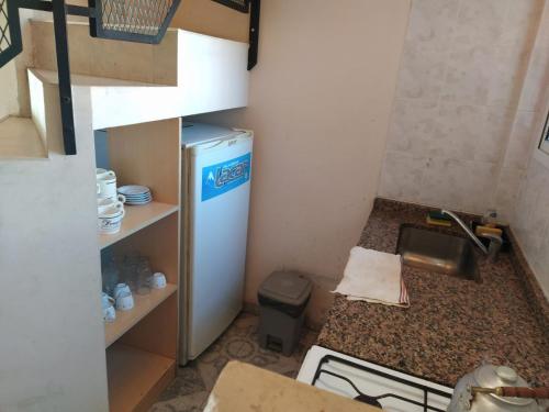 a small kitchen with a sink and a refrigerator at Perick Termas in Colón