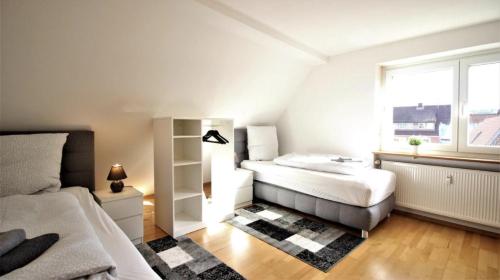 1 dormitorio con 2 camas y ventana en Zwei Ferienwohnungen in Randersacker, en Randersacker