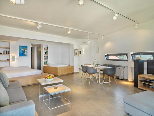 ein Schlafzimmer und ein Wohnzimmer mit einem Bett und einem Tisch in der Unterkunft Alectrona Living Crete, RocSea Luxury Apartment in Platanias