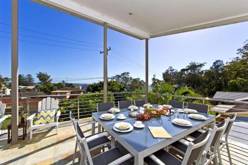 a dining table on the balcony of a house at Beachside Haven - Your Perfect Oasis Home in Nelson Bay