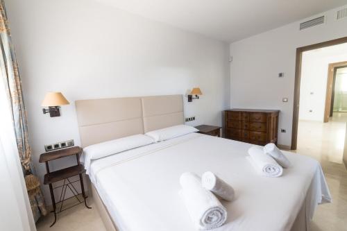 a bedroom with a large white bed with towels on it at Private Villa Martaver, swiming pool, BBQ & Pool table in Muchamiel
