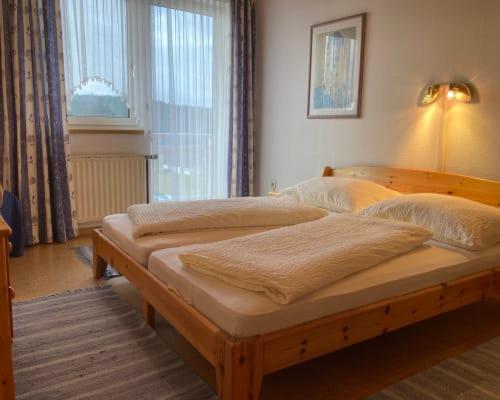 a bedroom with a wooden bed with pillows on it at Ferienwohnung Kratochvil in Bernreith