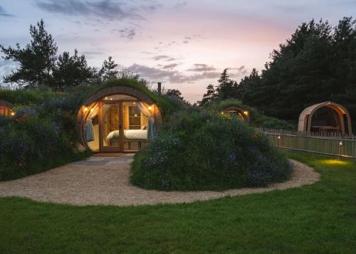 a round house with a bed in a garden at Luckington Burrows in Frome