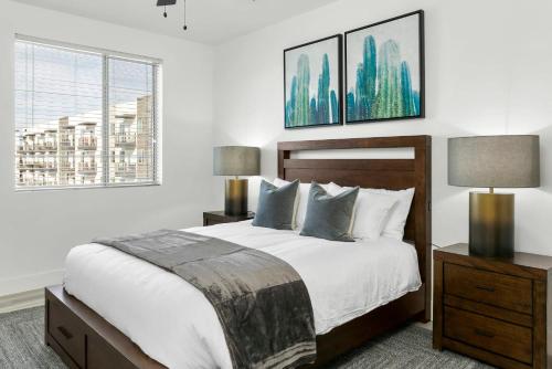 a bedroom with a bed and two lamps and a window at Premium One and Two Bedroom Apartments at Slate Scottsdale in Phoenix Arizona in Scottsdale