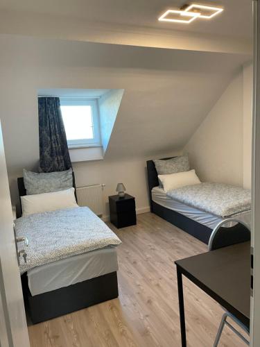 a small room with two beds and a table at Ferienwohnung Rastatt in Rastatt