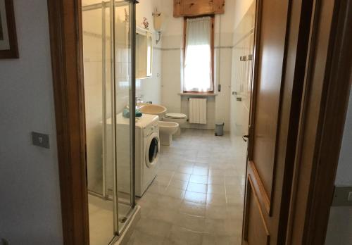 ein Badezimmer mit 2 WCs und einer Waschmaschine in der Unterkunft Casa Dani con piscina privata in Monticiano