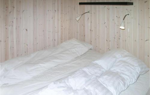 een bed met witte lakens en twee lampjes aan de muur bij Cozy Home In Hadsund With Wifi in Haslevgårde
