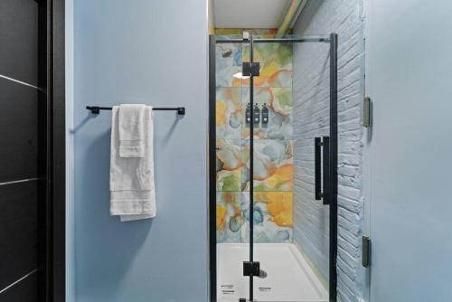 La salle de bains est pourvue d'une douche avec une porte en verre. dans l'établissement Artistic Cozy Loft Retreat, à Brooklyn