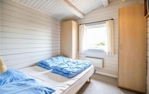 a bed in a room with a window at Awesome Home In Ebeltoft With 3 Bedrooms, Sauna And Wifi in Ebeltoft
